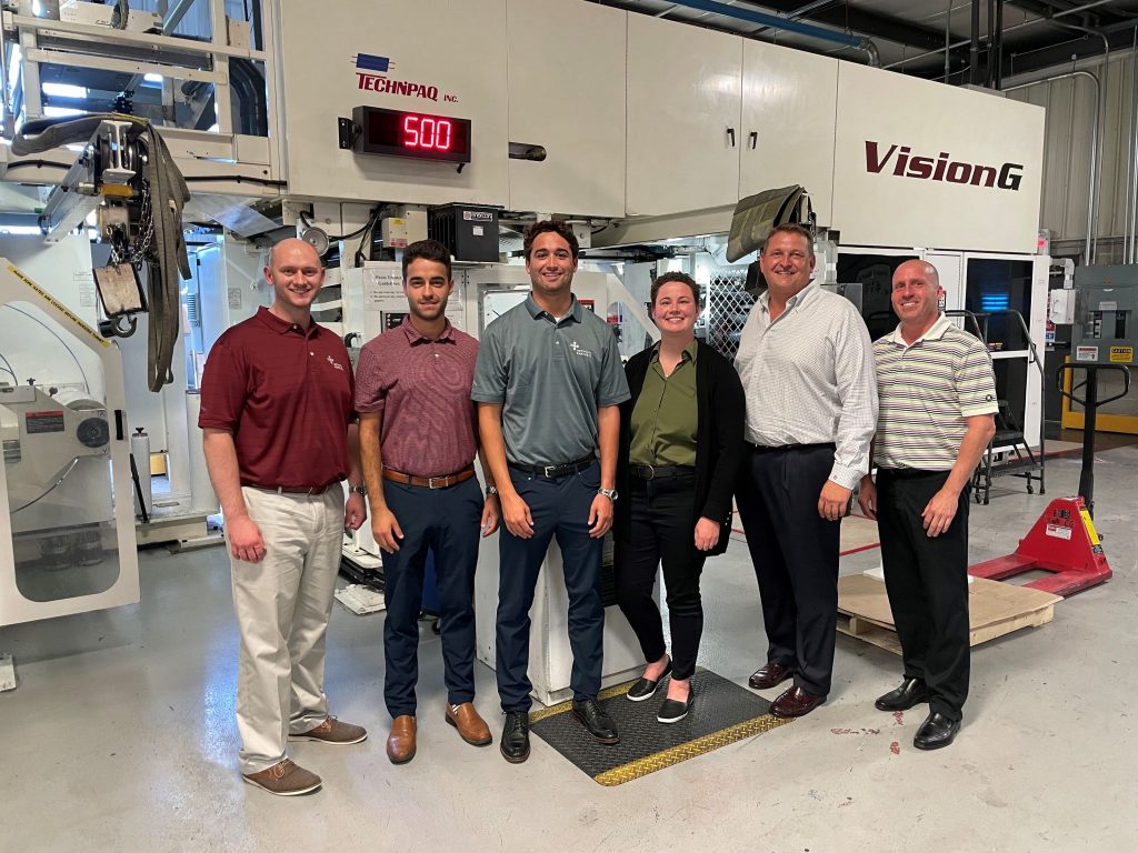 technipaq team standing in front of medical packaging equipment